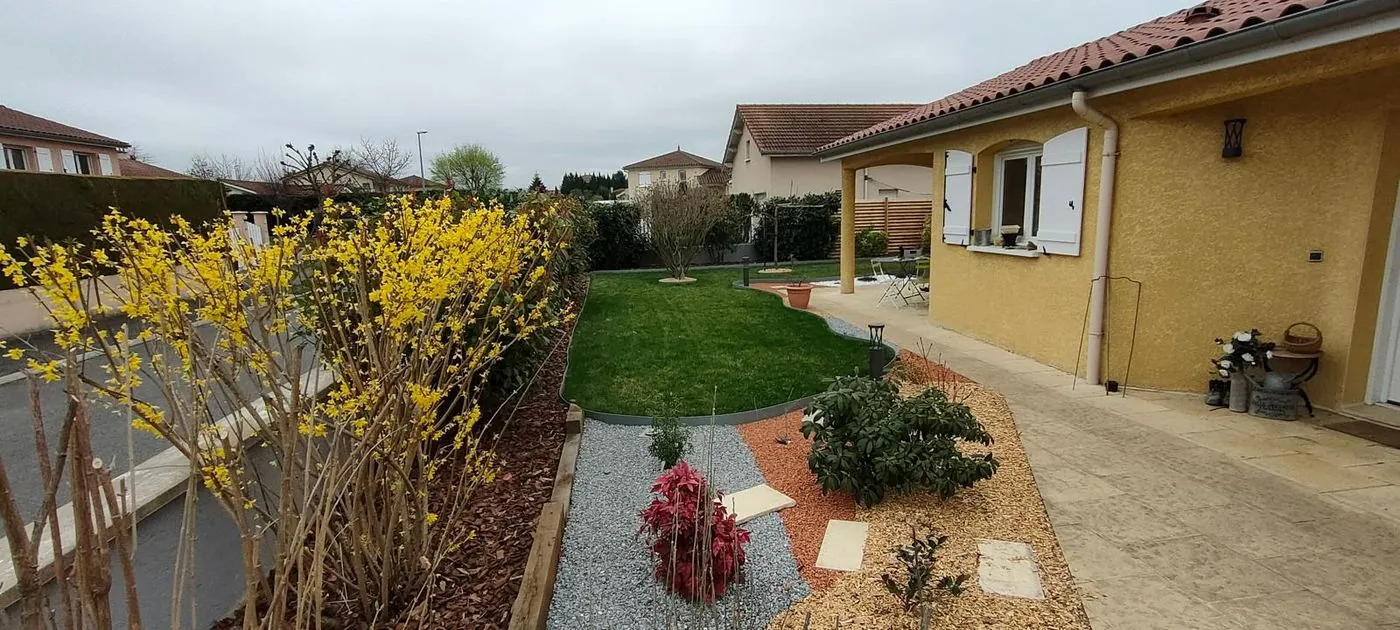 Jardin de devant : pelouse, massifs paillés et bordures.