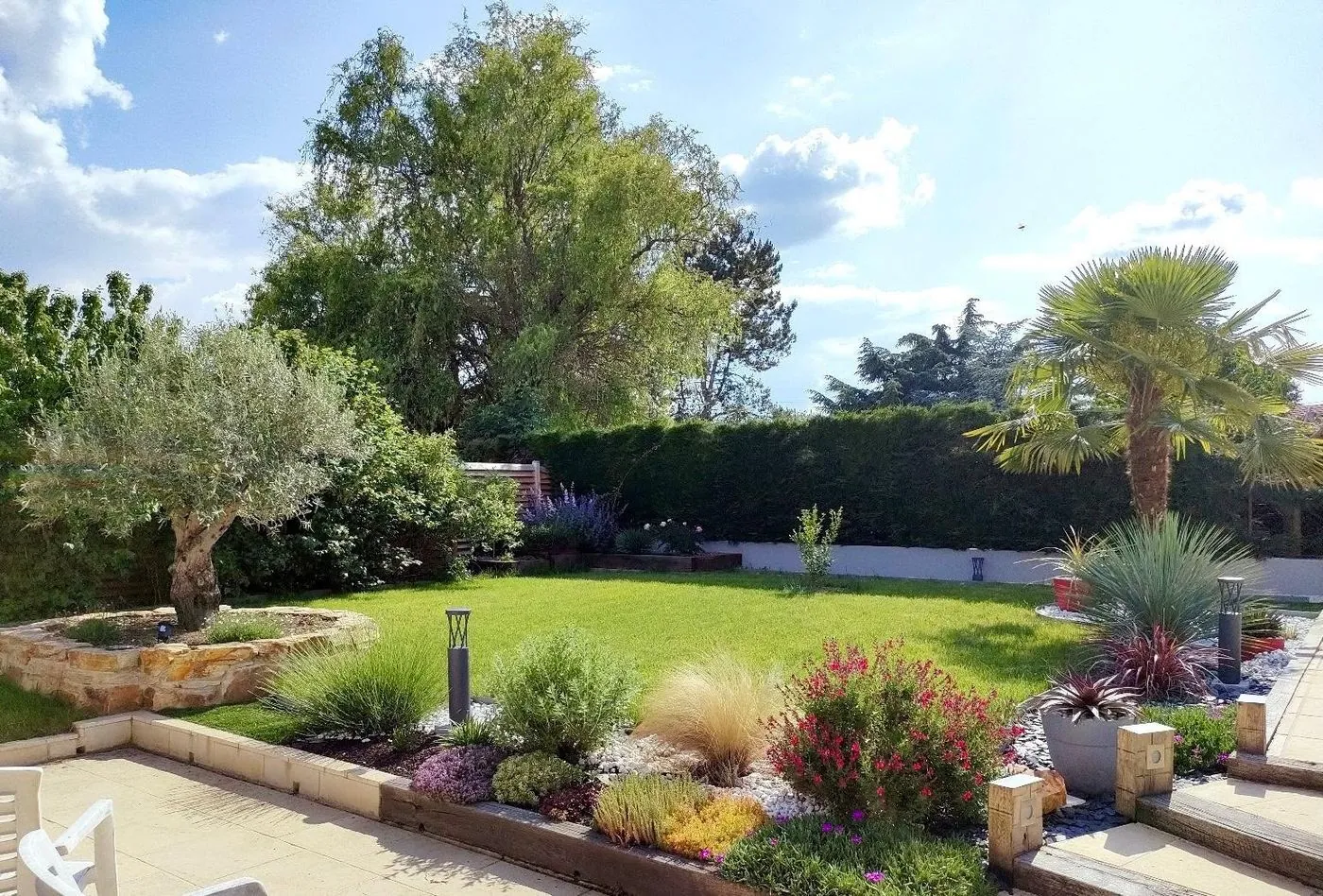 Jardin paysager : pelouse et massifs plantés.
