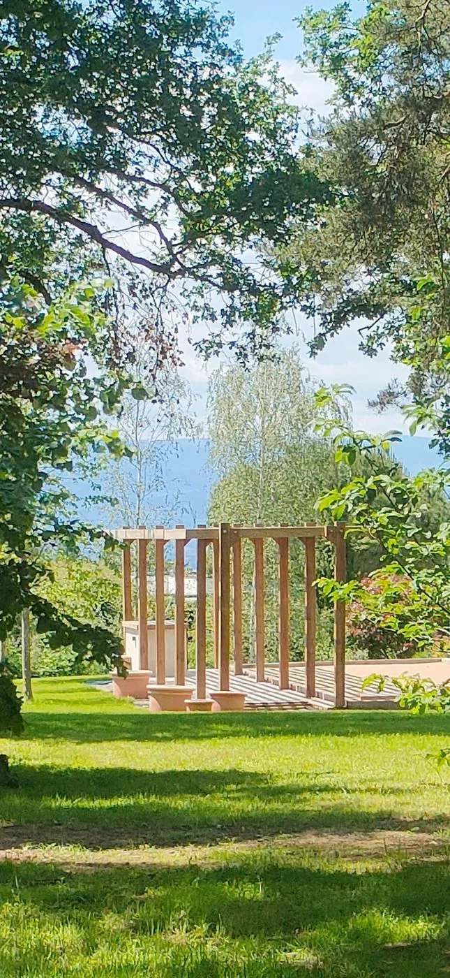 Pergola bois et pelouse dans un grand jardin.