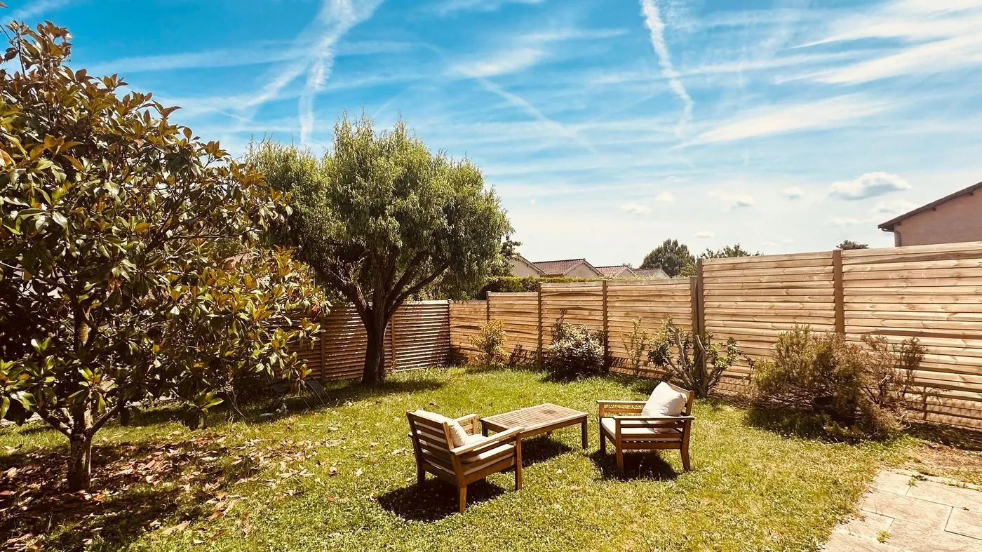Coin détente avec brise-vue bois et salon de jardin.